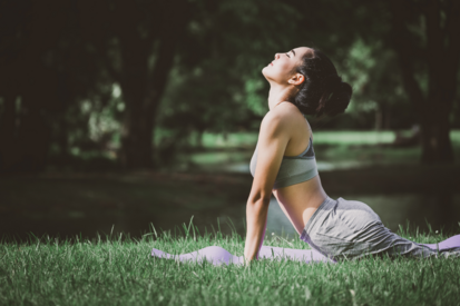 Frau macht Yoga auf einer Wiese