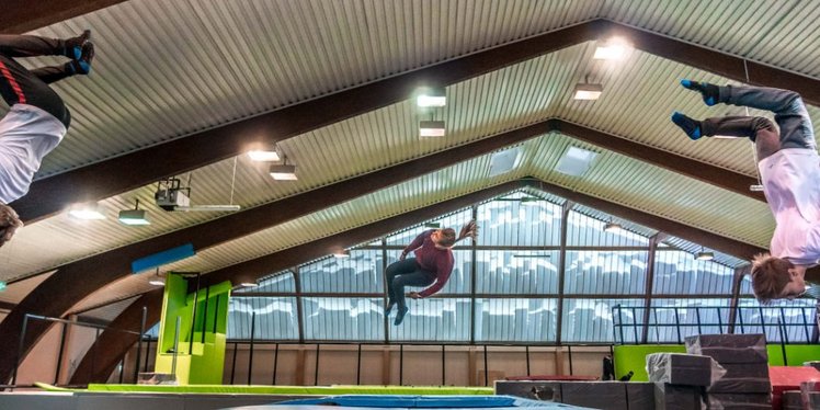 Zwei Jugendliche machen einen Salto über einem Trampolin im JUMP DOME Linz.